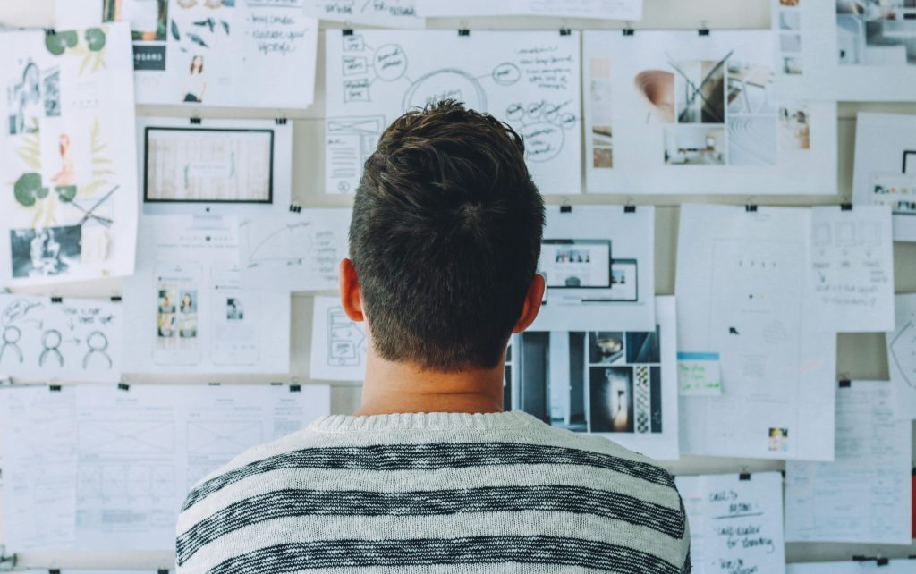 Photo by Startup Stock Photos: https://www.pexels.com/photo/man-wearing-black-and-white-stripe-shirt-looking-at-white-printer-papers-on-the-wall-212286/